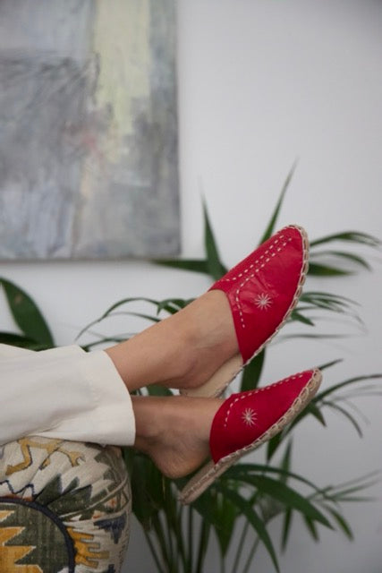 Leather handmade Egyptian slippers, ruby red leather on top and tan leather sole, white hand stitching through the red leather, pointed toe and flat sole