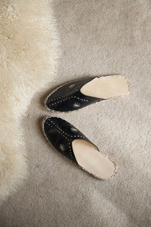 Leather handmade Egyptian slippers, midnight black leather on top and tan leather sole, white hand stitching through the black leather, pointed toe and flat sole
