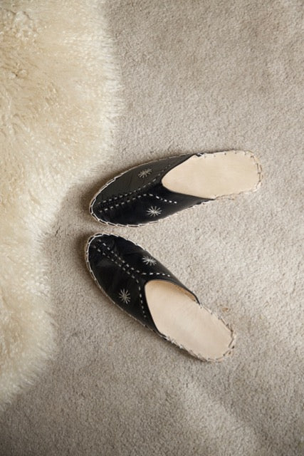 Leather handmade Egyptian slippers, midnight black leather on top and tan leather sole, white hand stitching through the black leather, pointed toe and flat sole