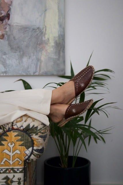 Leather handmade Egyptian slippers, chocolate brown leather on top and tan leather sole, white hand stitching through the brown leather, pointed toe and flat sole